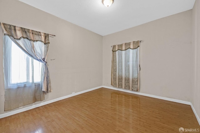 empty room with baseboards and wood finished floors