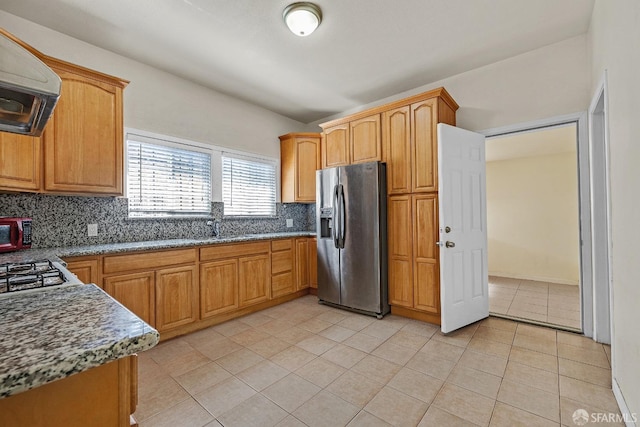 kitchen featuring stainless steel fridge, light tile patterned flooring, decorative backsplash, and extractor fan