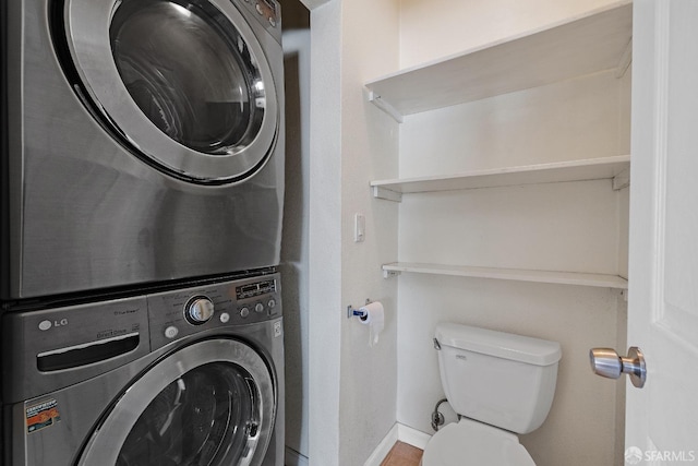 laundry room with stacked washing maching and dryer, baseboards, and laundry area