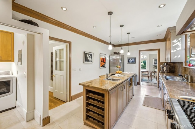 kitchen featuring light tile patterned flooring, a kitchen island, washer / clothes dryer, hanging light fixtures, and stainless steel range oven