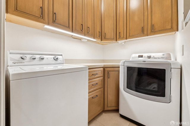 washroom featuring cabinets, light tile patterned floors, and independent washer and dryer