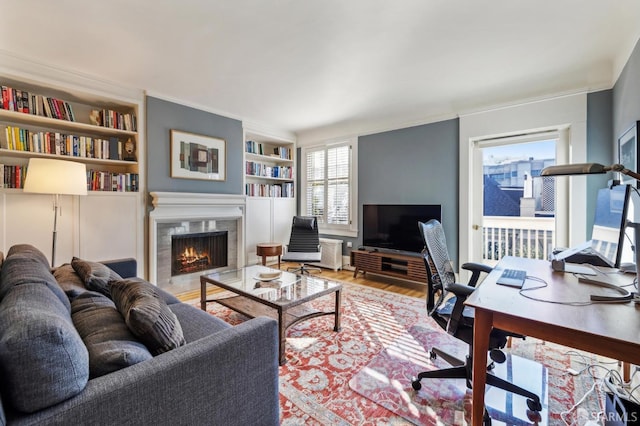 living room featuring hardwood / wood-style flooring, a fireplace, and built in shelves