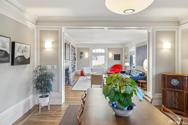 dining area featuring ornamental molding and wood-type flooring