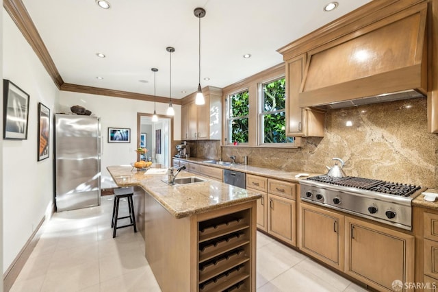 kitchen with tasteful backsplash, hanging light fixtures, appliances with stainless steel finishes, custom range hood, and a kitchen island with sink