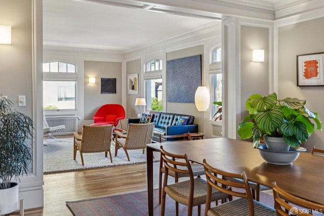 dining space with ornamental molding and light wood-type flooring