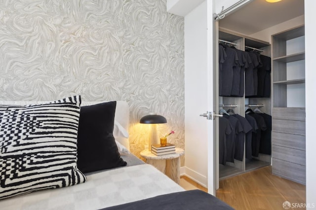 338 Main St Unit Ph36B, San Francisco, CA 94105 - bedroom featuring wallpapered walls, a closet, wood finished floors, and baseboards