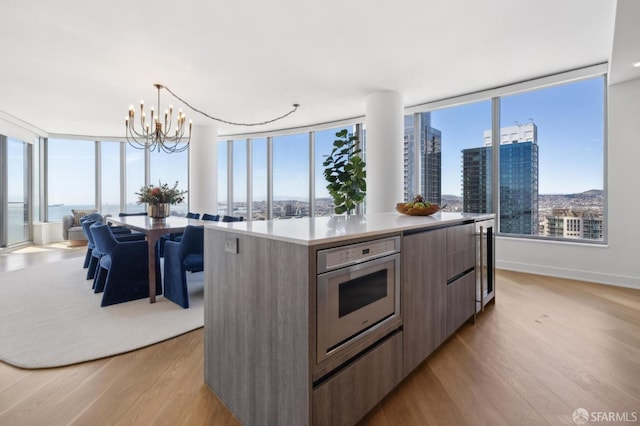 338 Main St Unit Ph36B, San Francisco, CA 94105 - kitchen with modern cabinets, a chandelier, light wood-type flooring, a kitchen island, and decorative light fixtures