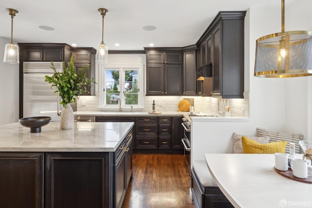 kitchen featuring sink, backsplash, dark hardwood / wood-style floors, and decorative light fixtures