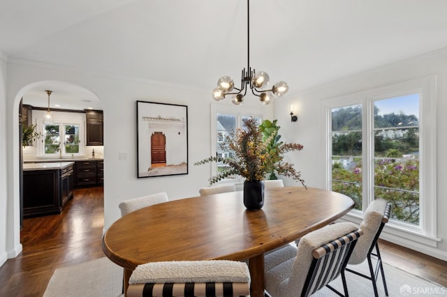 dining area featuring a notable chandelier, crown molding, and dark parquet floors