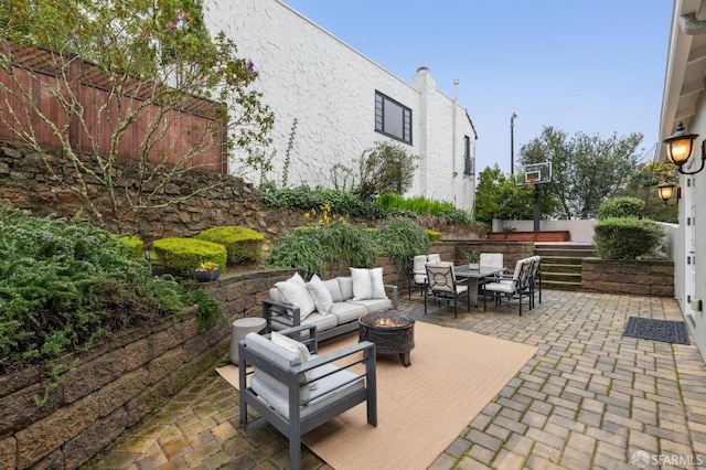 view of patio with an outdoor living space with a fire pit