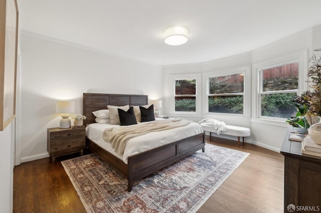 bedroom featuring hardwood / wood-style flooring, ornamental molding, and multiple windows