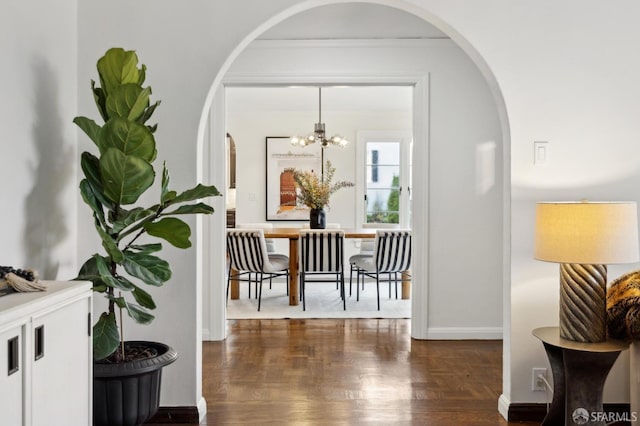 hall featuring crown molding and a chandelier