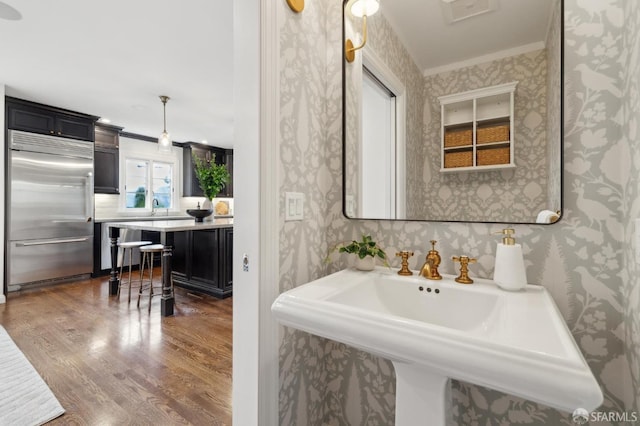 bathroom featuring crown molding, wood-type flooring, and sink