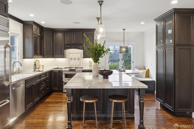 kitchen featuring stainless steel appliances, a healthy amount of sunlight, hanging light fixtures, and sink