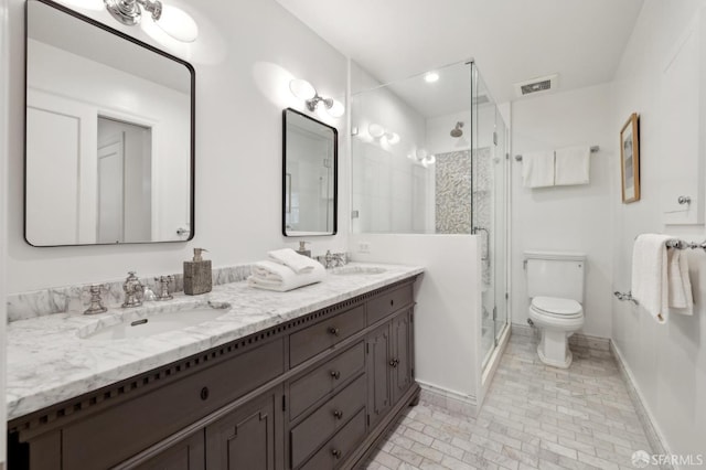 bathroom featuring a shower with door, vanity, and toilet