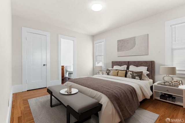 bedroom with baseboards and wood finished floors