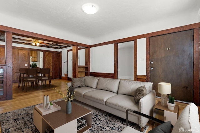 living area with a ceiling fan and wood finished floors