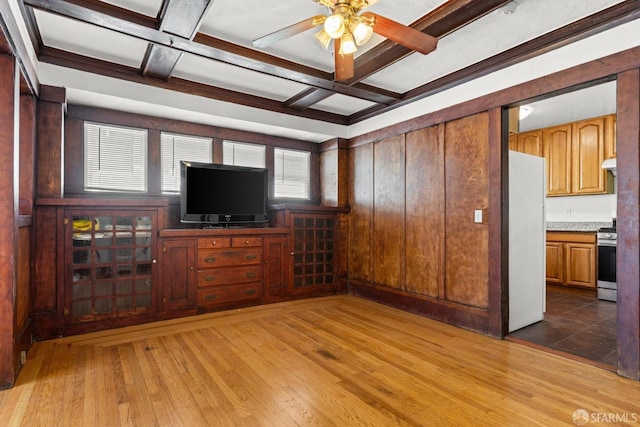 unfurnished living room featuring coffered ceiling, wood finished floors, and beamed ceiling