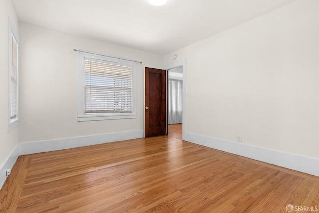 spare room with wood finished floors and baseboards