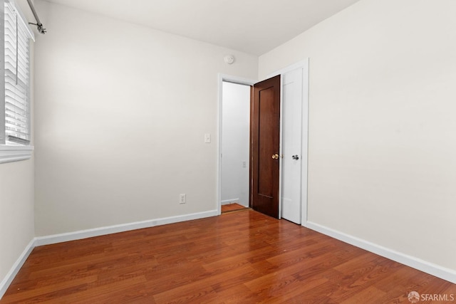 empty room with baseboards and wood finished floors