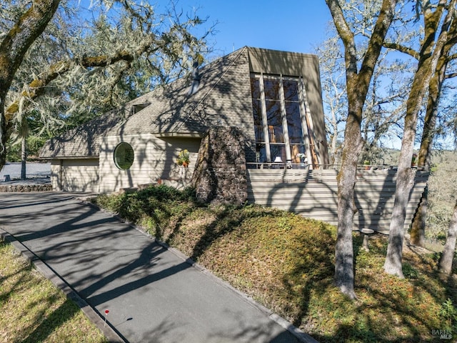 view of front of property featuring aphalt driveway, an attached garage, and fence