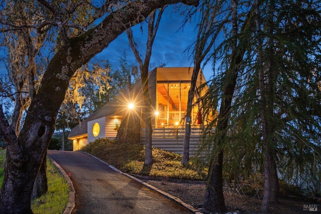 view of side of home with aphalt driveway and a fenced front yard