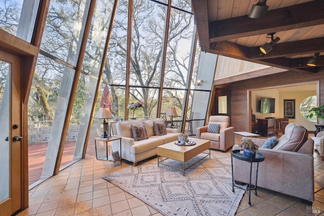 living area featuring beam ceiling, wood walls, wood ceiling, and expansive windows