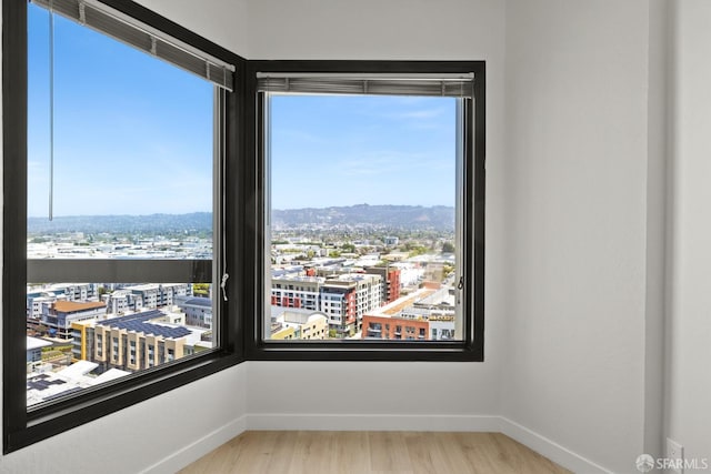 6363 Christie Ave Unit 1823, Emeryville, CA 94608 - unfurnished room with baseboards, a city view, and wood finished floors