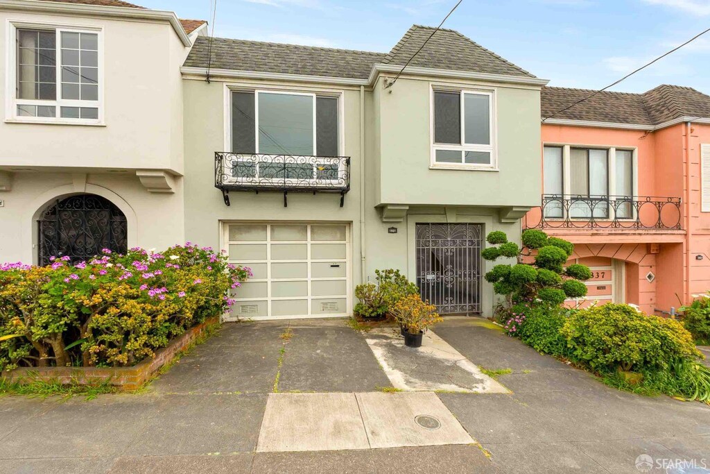 townhome / multi-family property featuring a garage, stucco siding, driveway, and roof with shingles