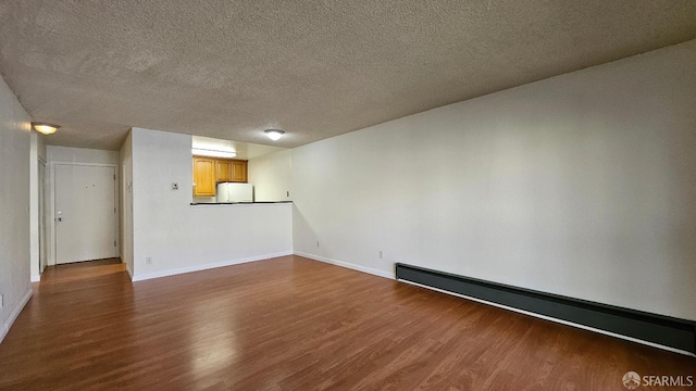 interior space with a baseboard heating unit, dark wood-type flooring, and a textured ceiling