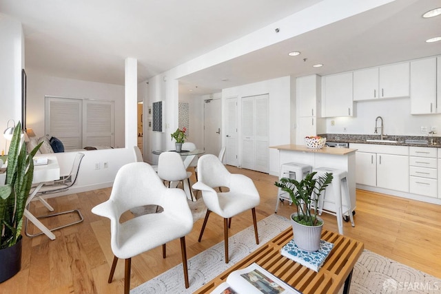 interior space with sink, white cabinets, and light hardwood / wood-style floors