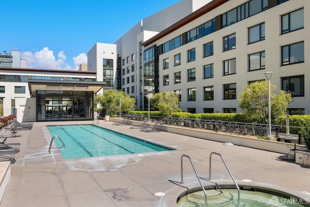 view of swimming pool with a hot tub and a patio