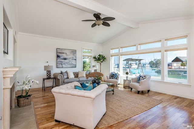 living room featuring lofted ceiling with beams, a fireplace with flush hearth, baseboards, light wood-type flooring, and crown molding