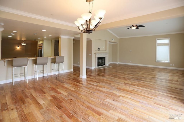 unfurnished living room featuring ceiling fan with notable chandelier, a fireplace with flush hearth, light wood-style flooring, and baseboards