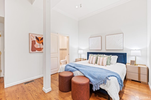 bedroom featuring visible vents, baseboards, crown molding, and wood finished floors