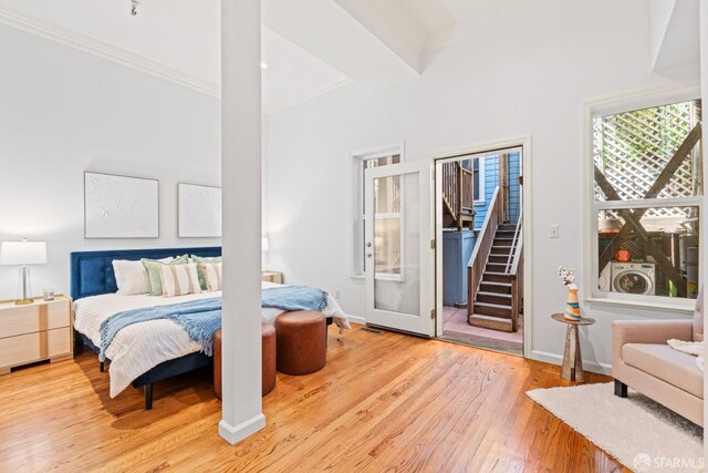 bedroom with wood-type flooring, a towering ceiling, baseboards, and crown molding