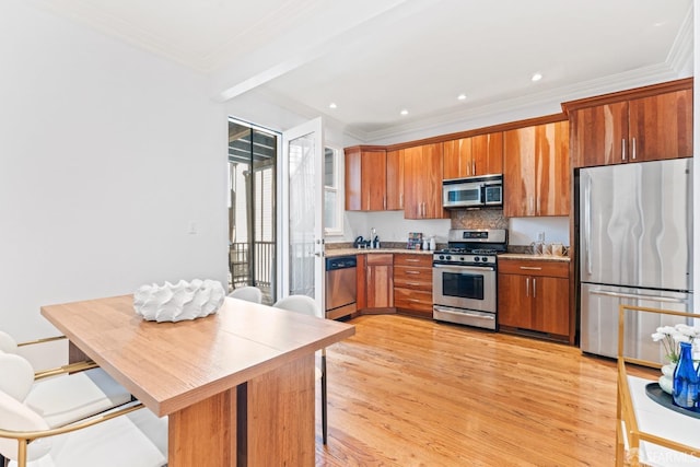 kitchen with a breakfast bar, ornamental molding, light wood-style flooring, brown cabinets, and stainless steel appliances