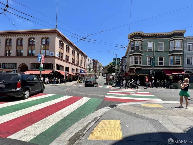 view of road featuring street lighting, sidewalks, curbs, and traffic signs