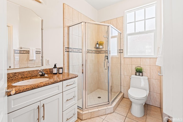 full bath with a shower stall, tile patterned floors, vanity, and toilet