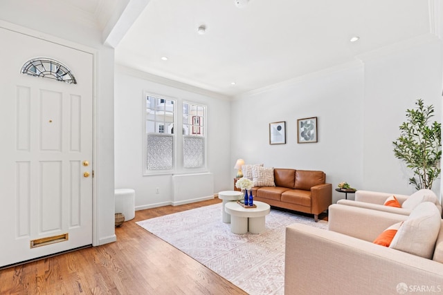 living room featuring crown molding, baseboards, light wood finished floors, and recessed lighting