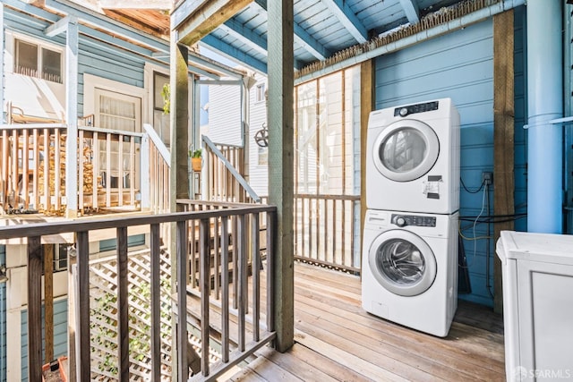 laundry area featuring hardwood / wood-style flooring and stacked washer and dryer
