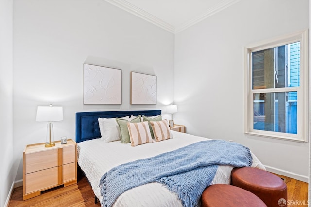 bedroom featuring crown molding, wood finished floors, and baseboards