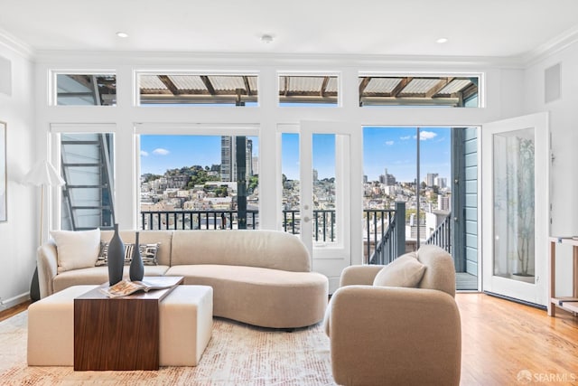 living room featuring wood finished floors, a view of city, and ornamental molding