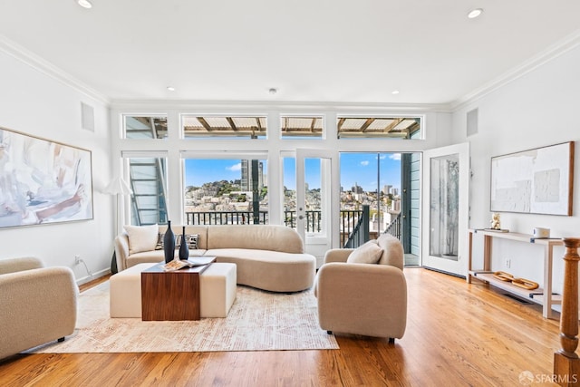 living room featuring baseboards, ornamental molding, recessed lighting, a view of city, and wood finished floors