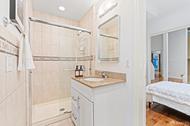 full bath with a shower stall, vanity, and wood finished floors