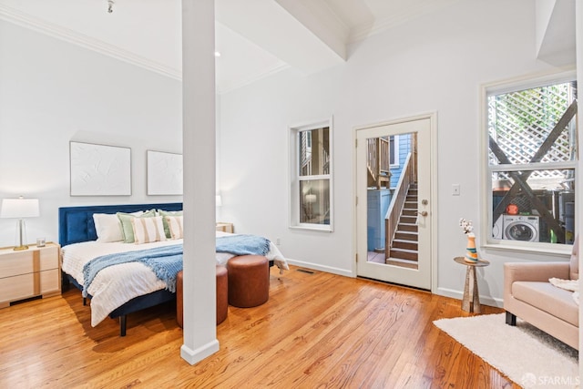 bedroom with washer / clothes dryer, access to outside, baseboards, ornamental molding, and hardwood / wood-style flooring