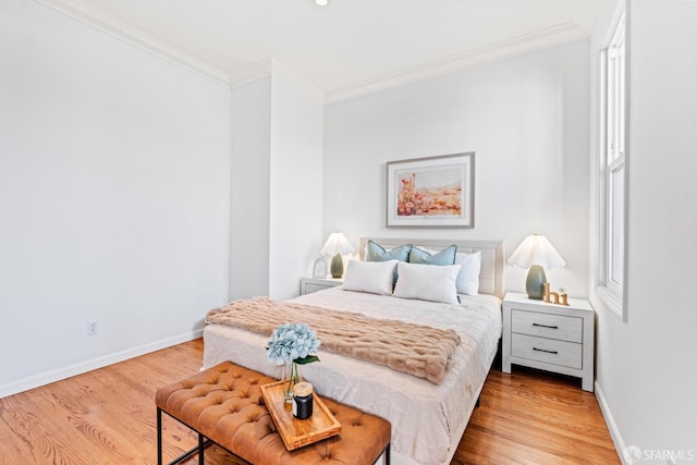 bedroom with ornamental molding, baseboards, and wood finished floors