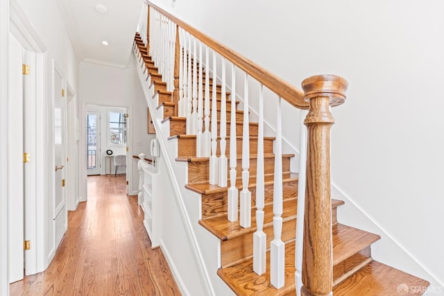 stairway with recessed lighting, crown molding, and wood finished floors