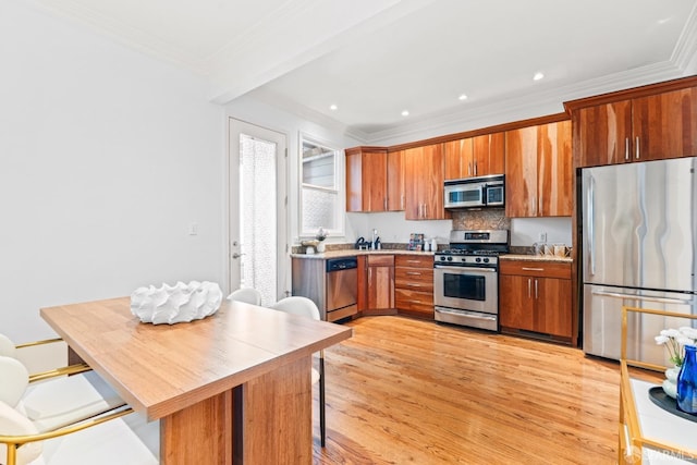 kitchen with light countertops, light wood-style floors, crown molding, brown cabinetry, and stainless steel appliances