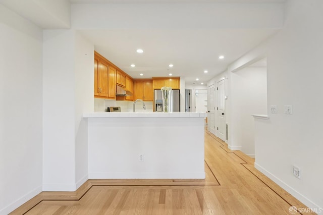104 Diamond Cove Ter, San Francisco, CA 94134 - kitchen with stainless steel fridge, a peninsula, tile counters, under cabinet range hood, and recessed lighting